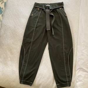 Tapered leg trousers with cuffed waistband, topstitching and pleating details.